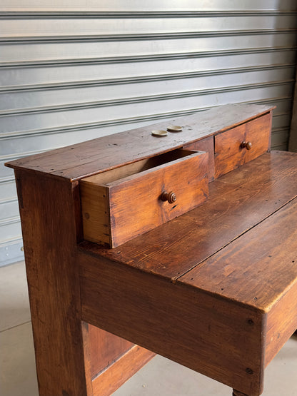 Ancien bureau à gradin de type comptoir, travail artisanal en bois massif du début du XXᵉ siècle.