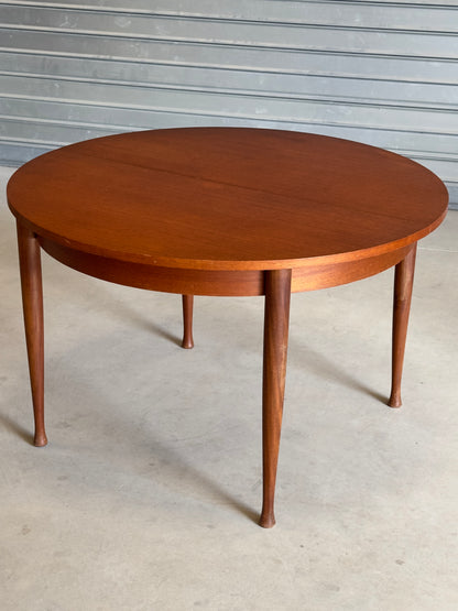 Table ronde vintage aux lignes épurées et au placage de teck chaleureux.