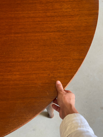 Table ronde vintage aux lignes épurées et au placage de teck chaleureux.