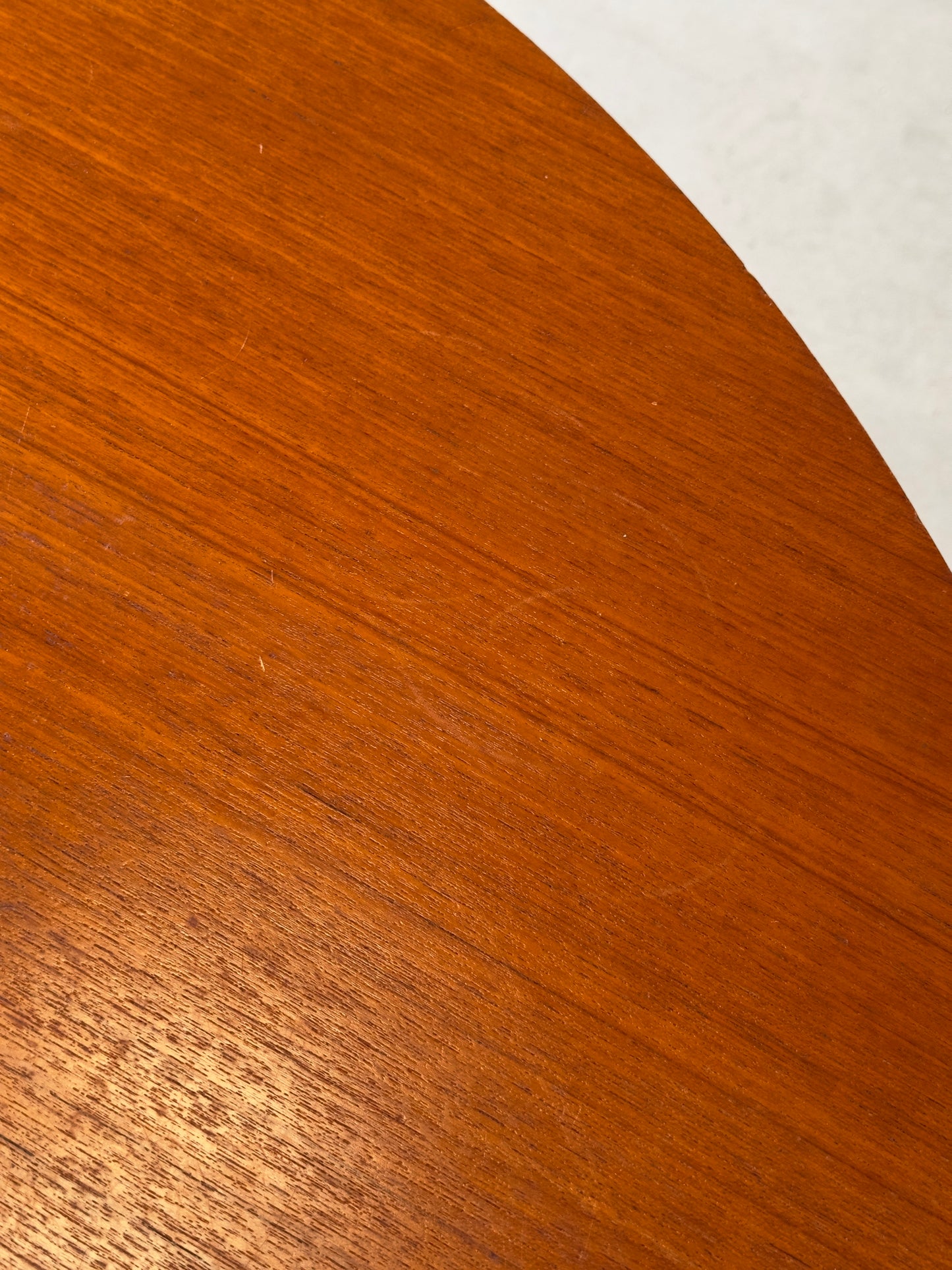 Table ronde vintage aux lignes épurées et au placage de teck chaleureux.