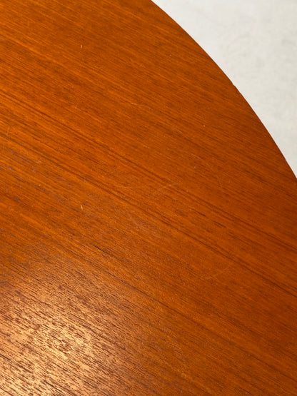 Table ronde vintage aux lignes épurées et au placage de teck chaleureux.