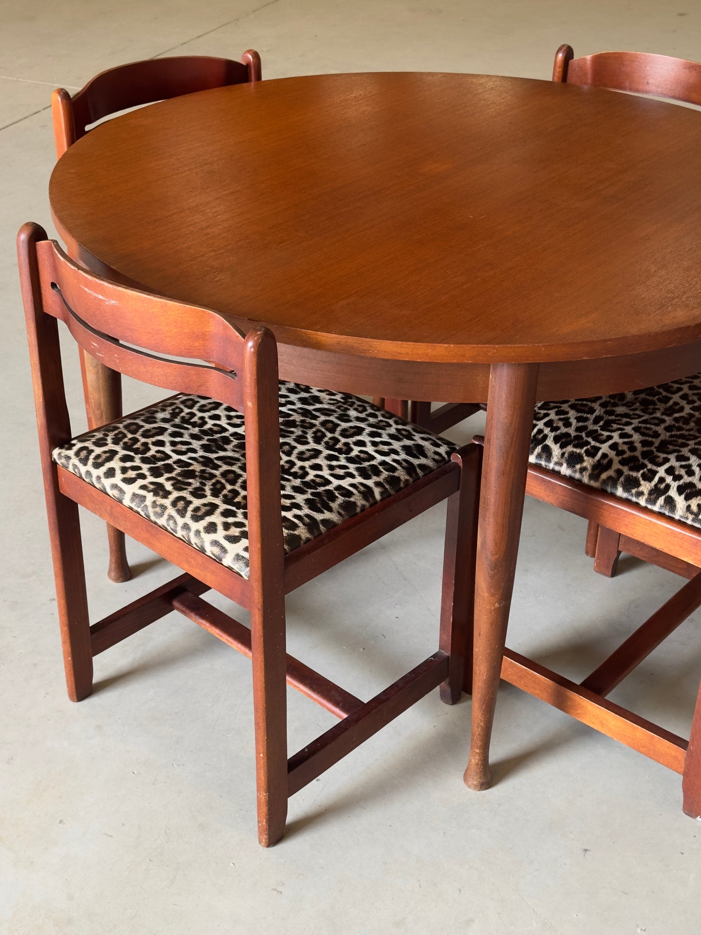 Table ronde vintage aux lignes épurées et au placage de teck chaleureux.
