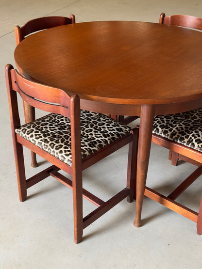 Table ronde vintage aux lignes épurées et au placage de teck chaleureux.