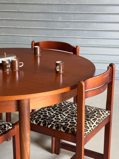 Table ronde vintage aux lignes épurées et au placage de teck chaleureux.