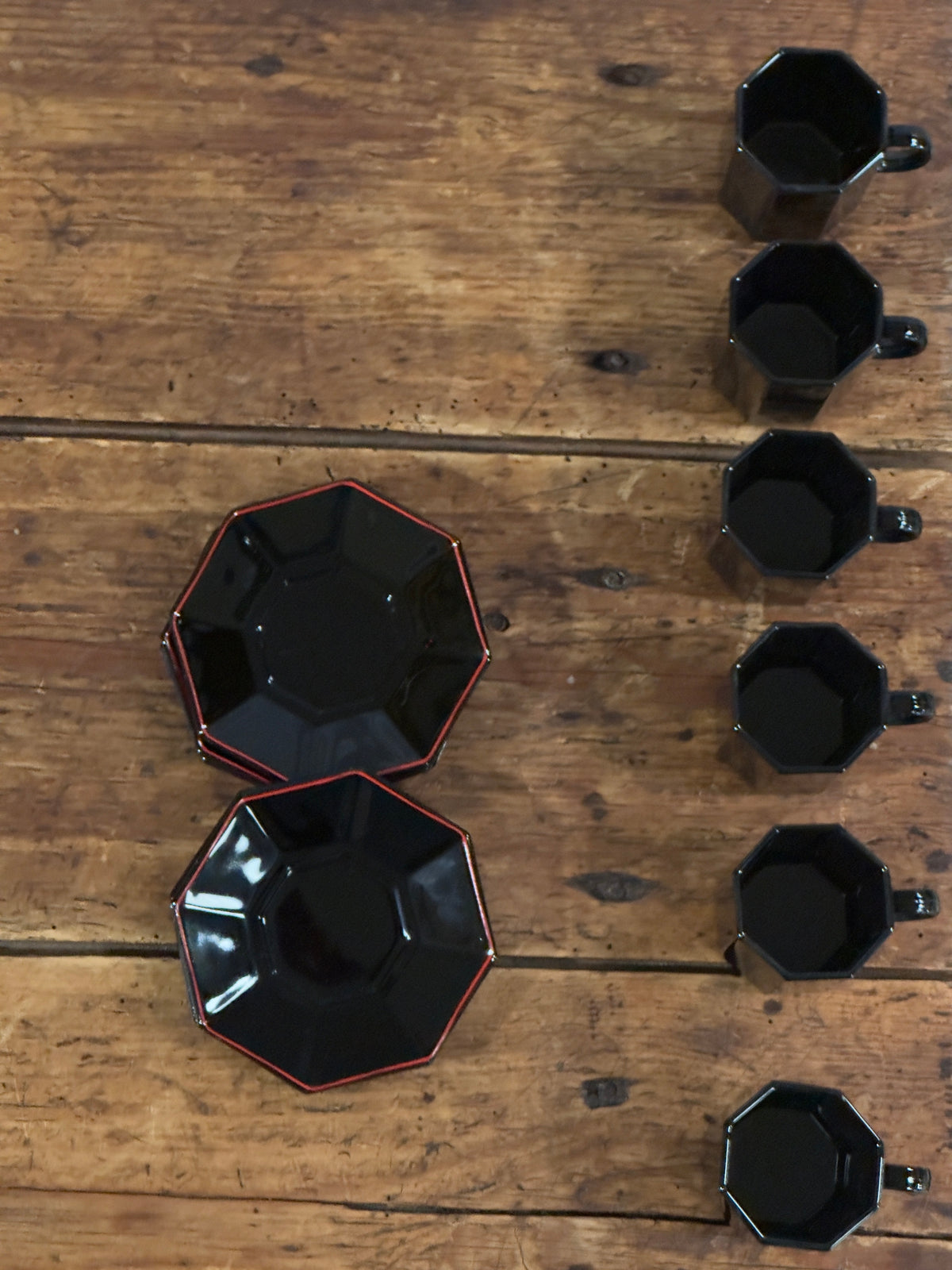 Un élégant service à café en céramique noire brillante, aux lignes facettées.