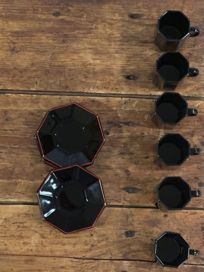 Un élégant service à café en céramique noire brillante, aux lignes facettées.