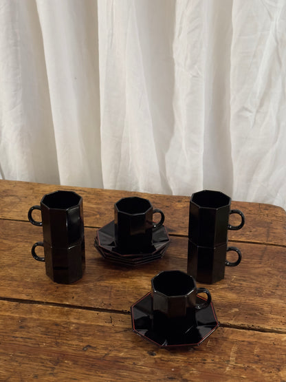 Un élégant service à café en céramique noire brillante, aux lignes facettées.