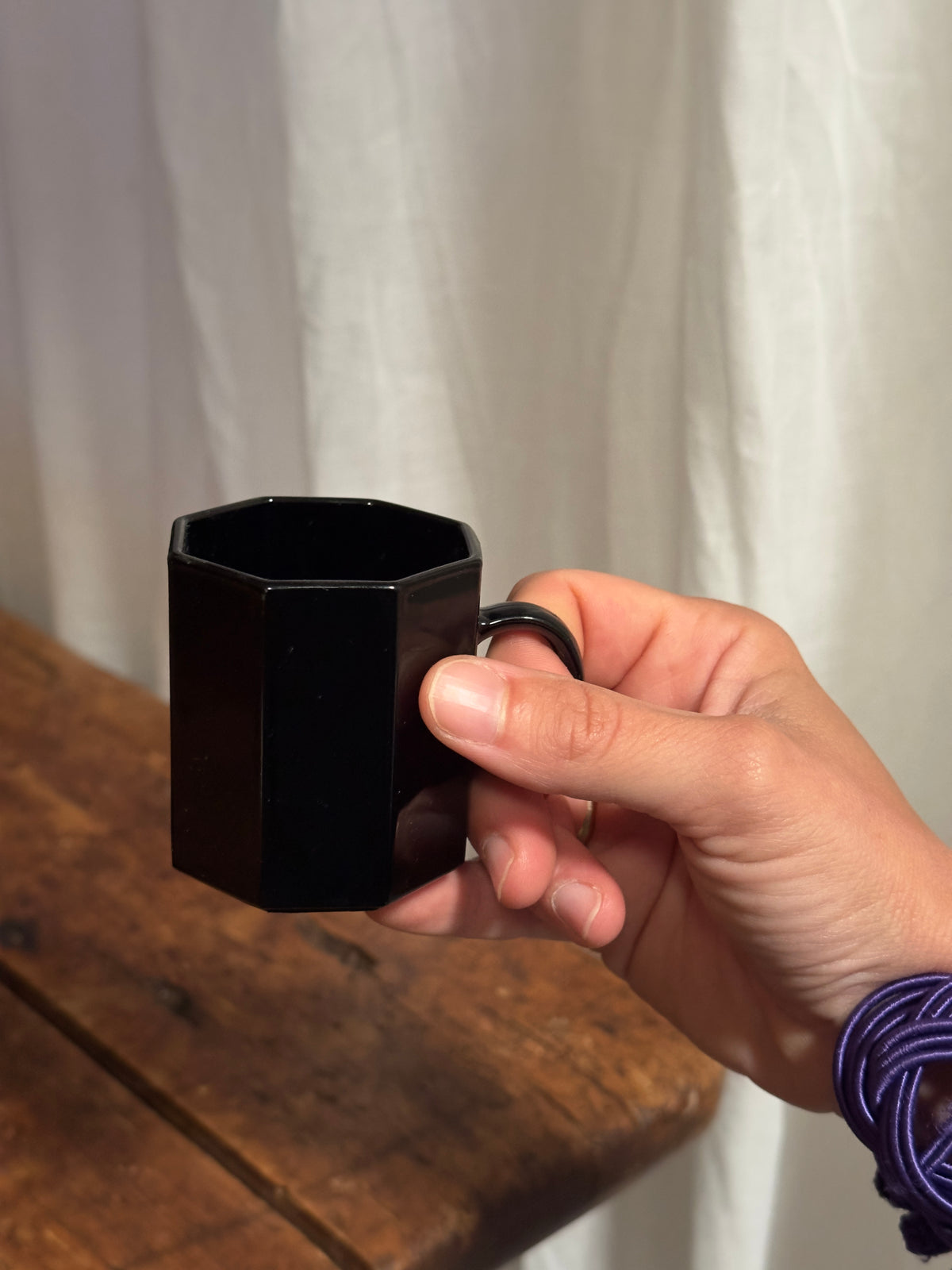 Un élégant service à café en céramique noire brillante, aux lignes facettées.