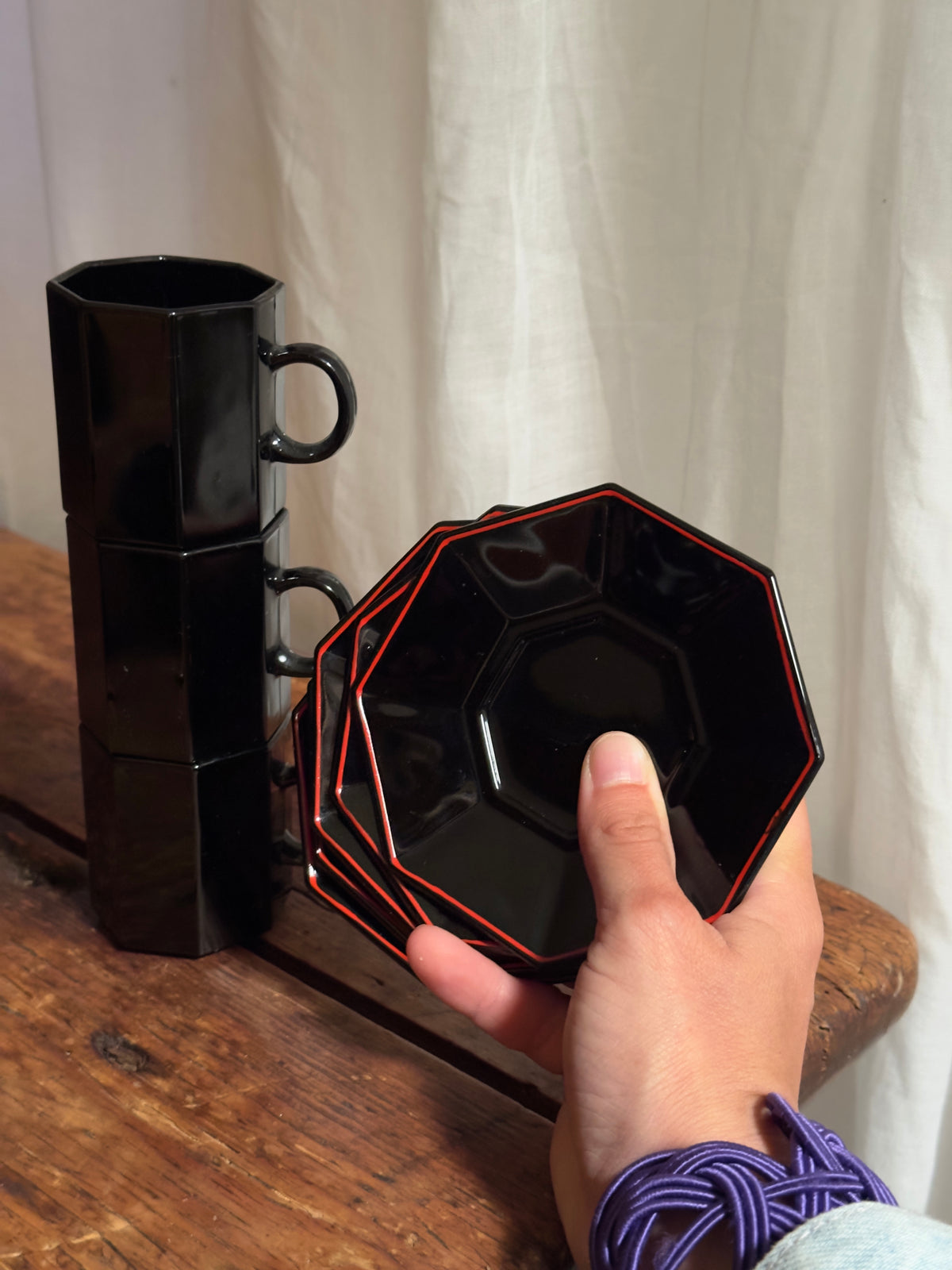 Un élégant service à café en céramique noire brillante, aux lignes facettées.